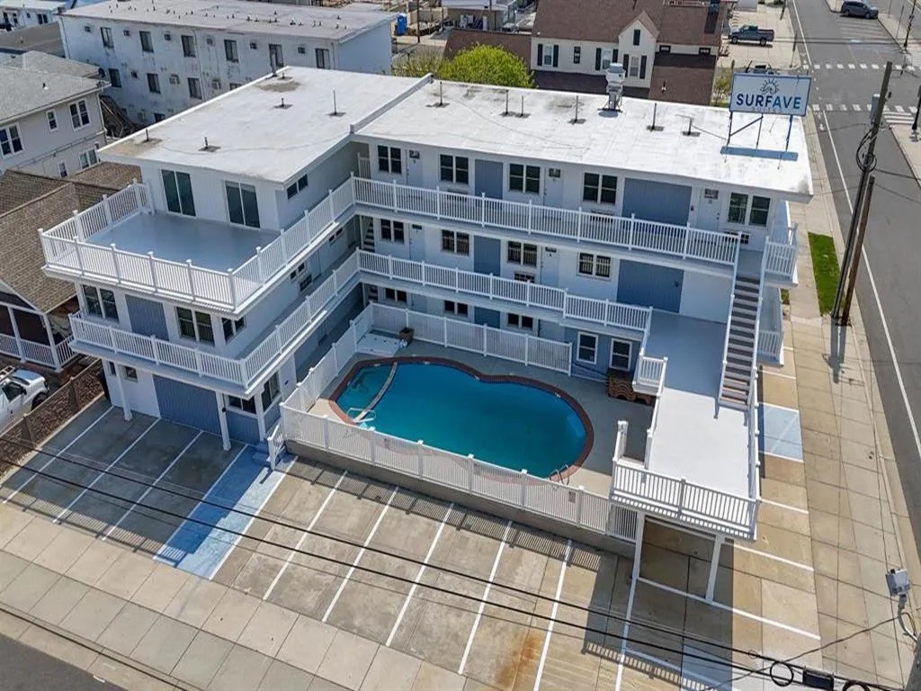 Aerial view of Surf Ave Suites showing the courtyard pool, balconies, and parking